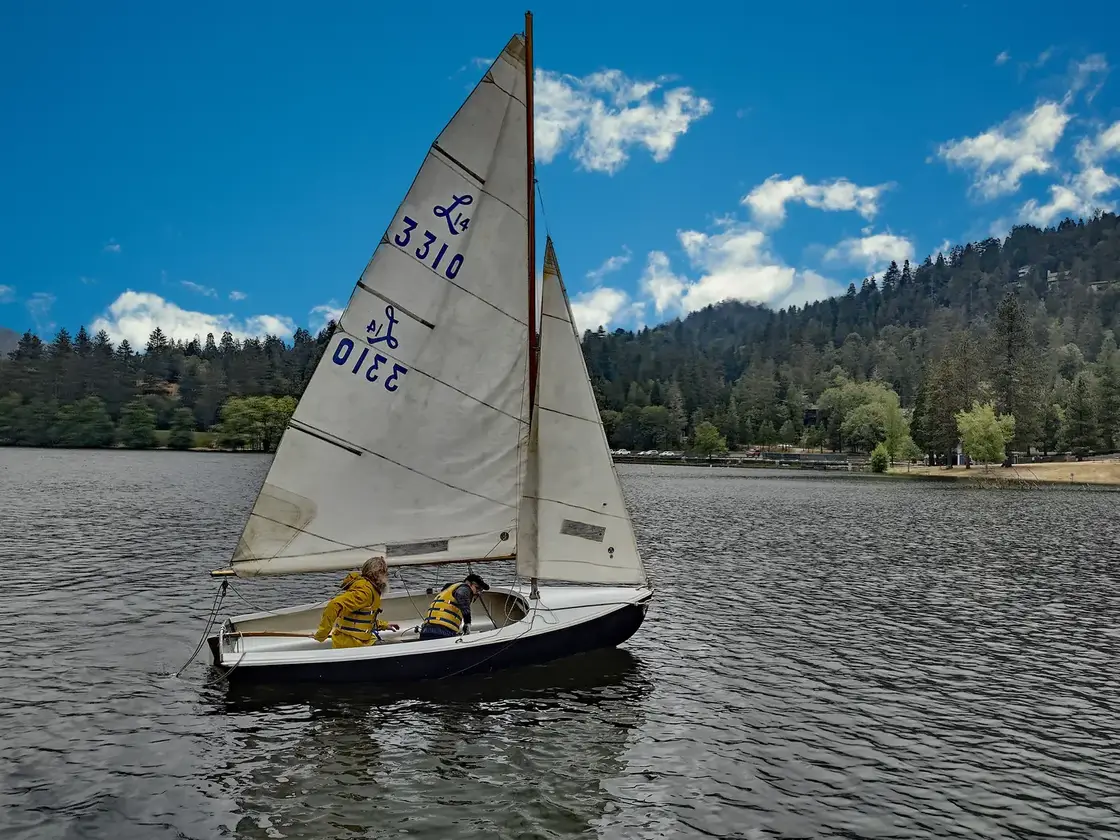 Two members sailing a club Lido 14 dinghy on Lake Gregory
